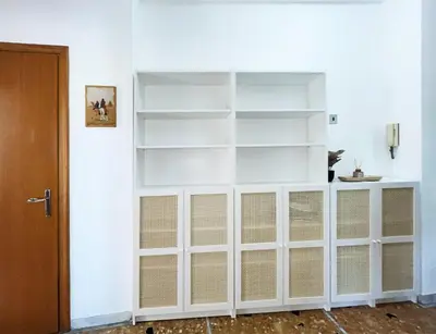 a white book shelf in a room with a door at La Casa di EDY - Metro Malatesta in Rome