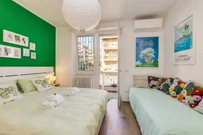 two beds in a room with a green wall at Vatican 10 min Modern apartment AC, Wi-Fi, Netflix in Rome