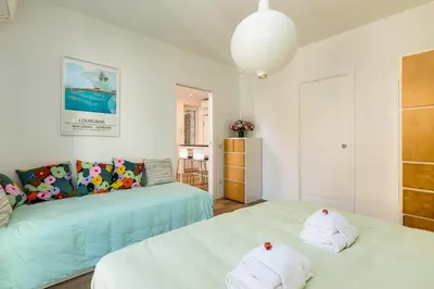 two beds in a room with white walls at Vatican 10 min Modern apartment AC, Wi-Fi, Netflix in Rome