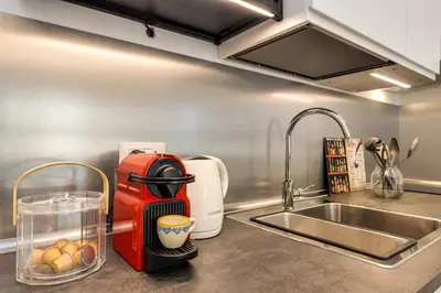 a kitchen counter with a coffee maker next to a sink at Vatican 10 min Modern apartment AC, Wi-Fi, Netflix in Rome