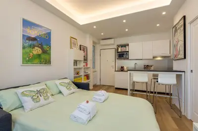 a living room with a bed and a kitchen at Vatican 10 min Modern apartment AC, Wi-Fi, Netflix in Rome