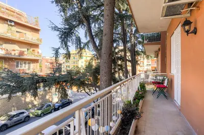 a balcony with a tree and a table and chairs at Vatican 10 min Modern apartment AC, Wi-Fi, Netflix in Rome