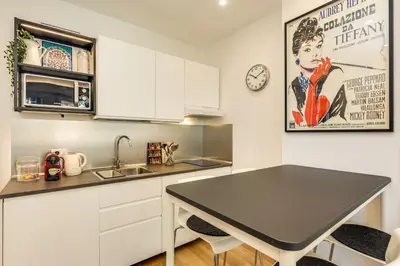 a kitchen with a black table and a sink at Vatican 10 min Modern apartment AC, Wi-Fi, Netflix in Rome