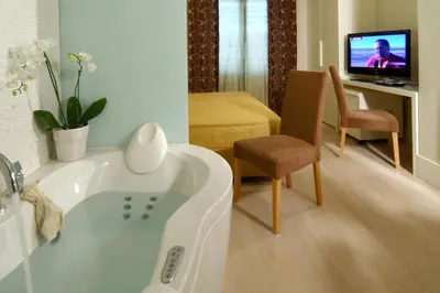 a bathroom with a tub and a tv in a room at Domus Adriani in Rome
