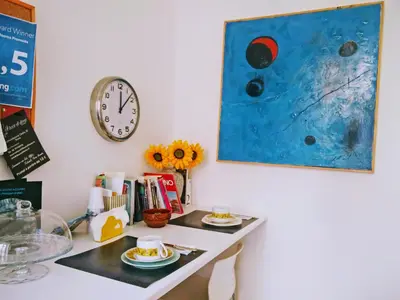 a desk with a clock and a table with plates of food at Rome Center Rooms in Rome