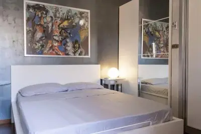 a bedroom with a white bed and a painting on the wall at Roma Centro appartamento in Rome