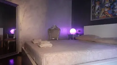 a bedroom with a bed with a mirror and purple lights at Roma Centro appartamento in Rome