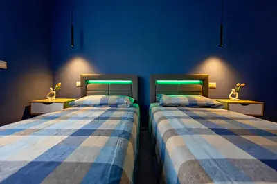two beds in a room with green lights at OASIS Of PEACE CLOSE TO VATICANO in Rome