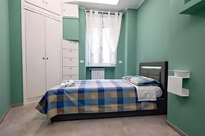 a bedroom with a bed with a blue and green wall at OASIS Of PEACE CLOSE TO VATICANO in Rome