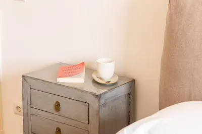 a bedside table with a cup and a book at Amazing Piazza Fiume in Rome