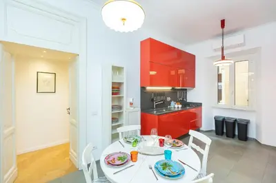 a kitchen with a white table and red cabinets at Amazing Piazza Fiume in Rome