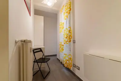 a hallway with a chair and a curtain in a room at GuestHost - Garbatella Comfy Apartment in Rome