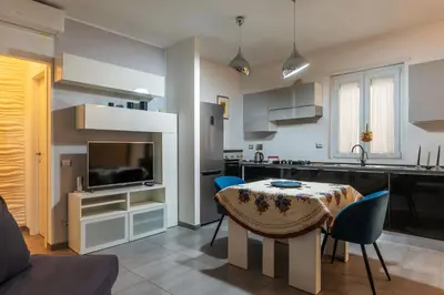 a kitchen and living room with a table and chairs at GuestHost - Garbatella Comfy Apartment in Rome