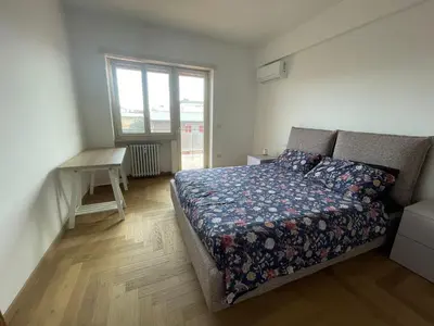 a bedroom with a bed and a desk and a window at la casa di Janis in Rome