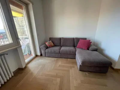 a living room with a couch and a large window at la casa di Janis in Rome
