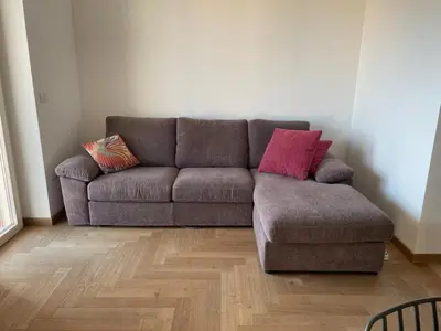 a couch with two pillows on it in a living room at la casa di Janis in Rome