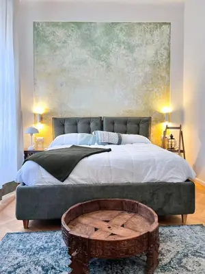 a bedroom with a large bed with a large painting at Roma Parioli - Manfredi Suites appartamento in Rome