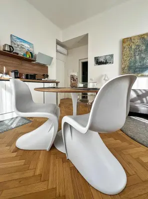 a dining room with white chairs and a table at Roma Parioli - Manfredi Suites appartamento in Rome