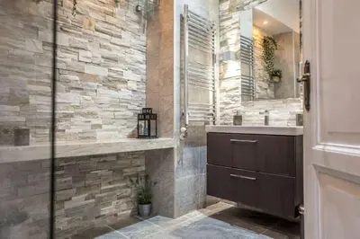 a bathroom with a sink and a stone wall at The 150 Home - Homkeey Apartments in Rome