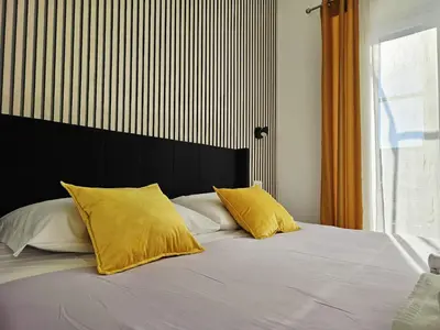 a bed with two yellow pillows on top of it at Upper San Pietro elegant flat on metro A with a view in Rome
