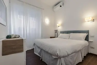 a bedroom with a large white bed and a window at 2-Bedroom Roman Gem in Rome