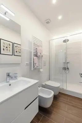 a white bathroom with a sink and a toilet at 2-Bedroom Roman Gem in Rome