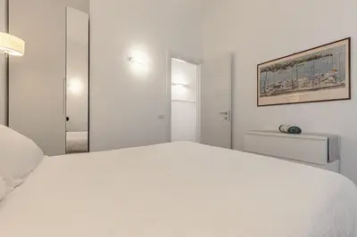 a white bedroom with a large white bed at 2-Bedroom Roman Gem in Rome