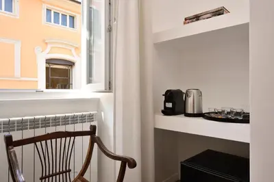 a chair in a room with a window at Palazzo Tridente Rooms in Rome