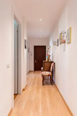 a hallway with a chair in a room with white walls at Dome At Home in Rome