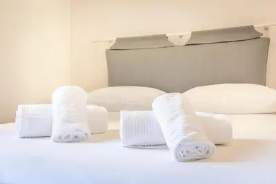 a group of white pillows on a bed at Dome At Home in Rome