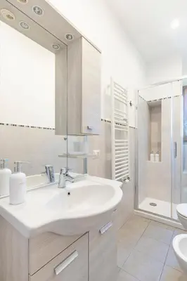 a white bathroom with a sink and a shower at Dome At Home in Rome