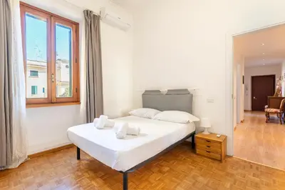 a bedroom with a white bed and a large window at Dome At Home in Rome