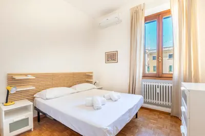 a bedroom with a white bed and a window at Dome At Home in Rome