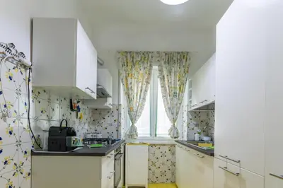 a kitchen with white cabinets and a window at Da Renny in Rome