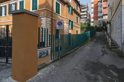 an empty street with a fence and a no parking sign at Da Renny in Rome