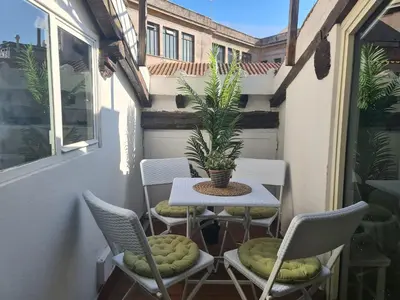 a table and chairs on a balcony with a plant at Boutique Domus Spagna Ripetta in Rome