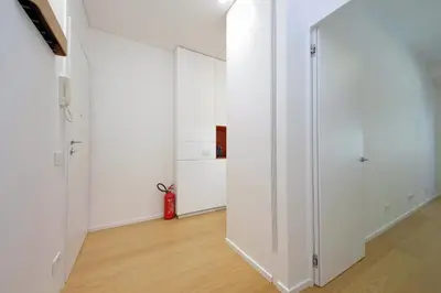 a hallway with white cabinets and a red fire extinguisher at 4BNB - Charming Giuliana Apartment in Rome