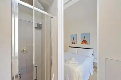 a white bedroom with a bed and a shower at 4BNB - Charming Giuliana Apartment in Rome