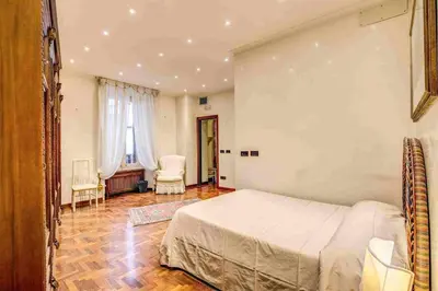 a bedroom with a large bed and two chairs at Feffyhouse in Rome