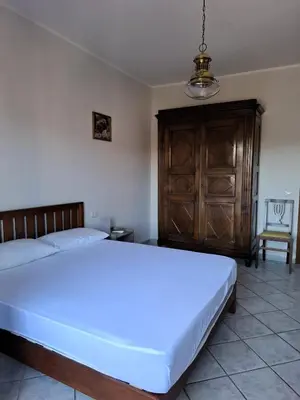 a bedroom with a large white bed and a chair at Locazione turistica di Alberto in Rome