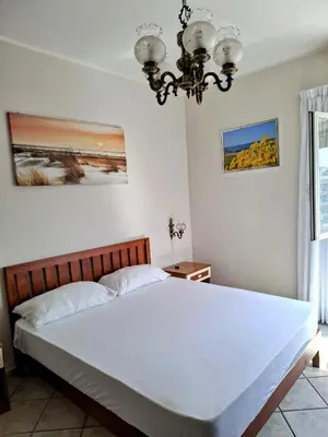 a large white bed in a bedroom with a chandelier at Locazione turistica di Alberto in Rome