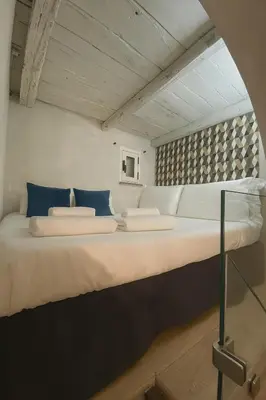 a bedroom with a large bed with blue and white pillows at éROMA - NAVONA Apartment in Rome