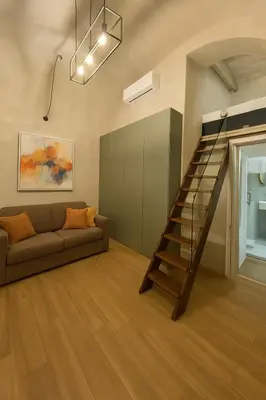 a living room with a couch and a staircase at éROMA - NAVONA Apartment in Rome