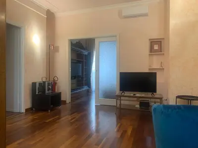 a living room with a television and a wooden floor at Trastevere AURA - Your Roman home with SOUL in Rome