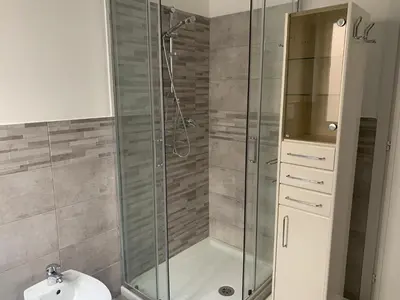 a bathroom with a glass shower with a toilet at Trastevere AURA - Your Roman home with SOUL in Rome