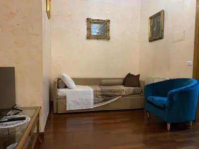 a bedroom with a bed and a blue chair at Trastevere AURA - Your Roman home with SOUL in Rome