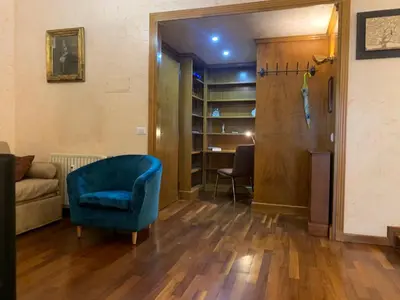 a living room with a blue chair and a desk at Trastevere AURA - Your Roman home with SOUL in Rome