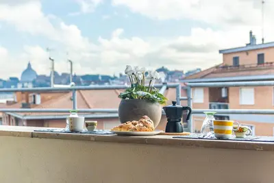 a table with a plate of food on a balcony at gandino apartment in Rome