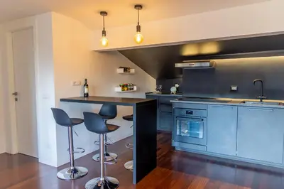 a large kitchen with blue cabinets and bar stools at gandino apartment in Rome