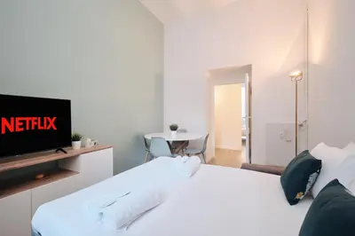 a bedroom with a white bed and a tv at Vatican Museums - Modern flat with Wi-Fi & Netflix in Rome